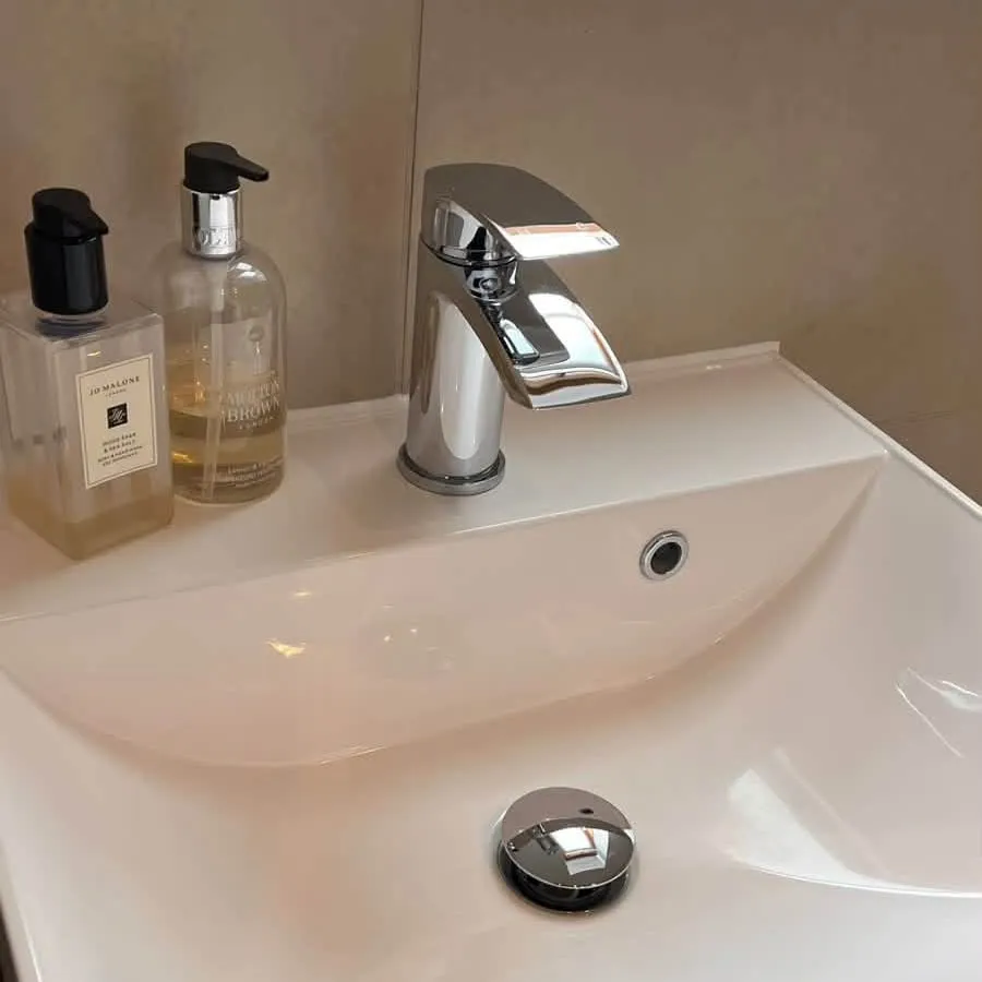 The same basin after cleaning, with a shining chrome tap and plug