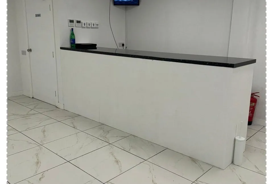 The finished reception area after a builders clean, with a clean counter and gleaming marble-effect floor